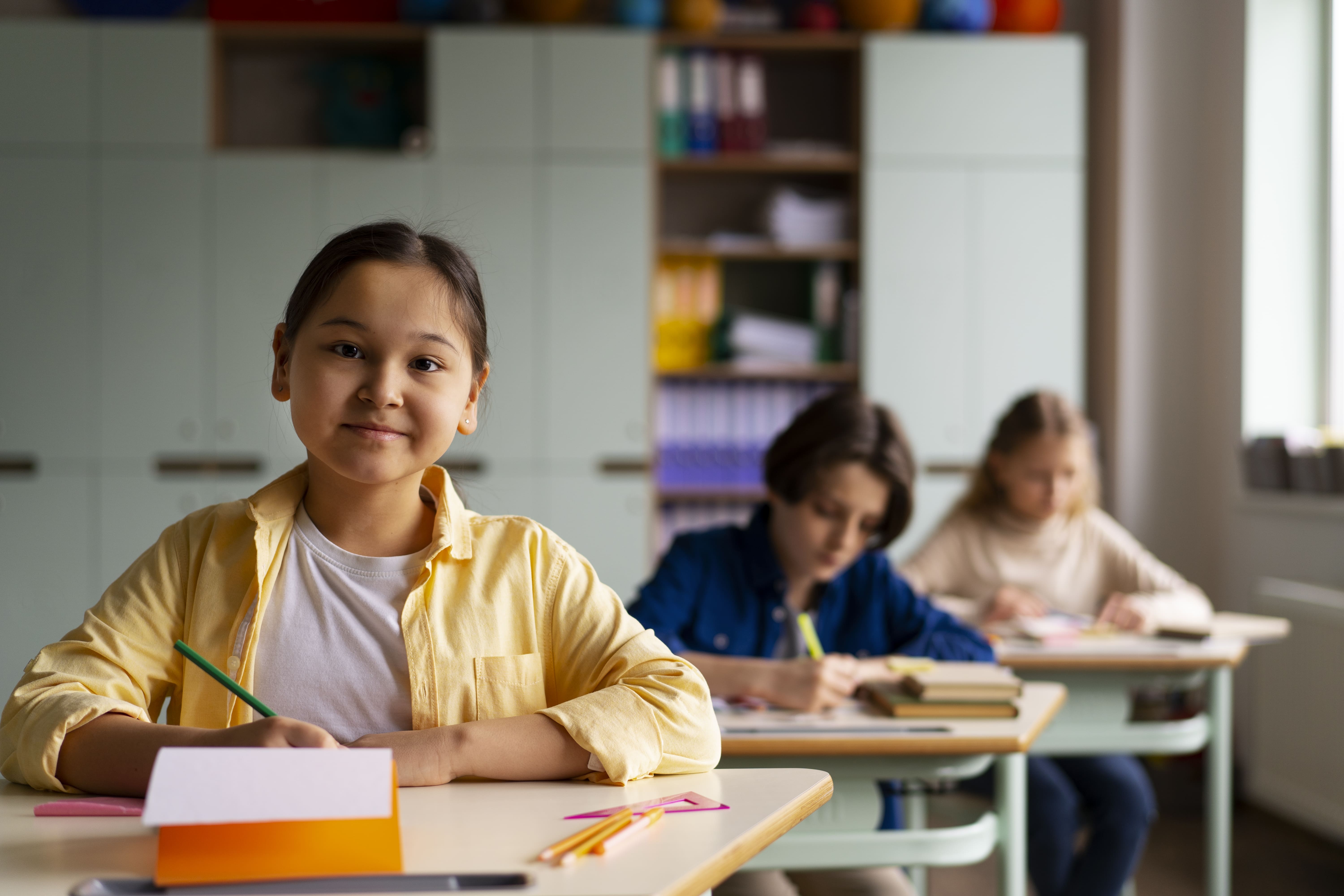 Niños en primaria estudiando atentamente en el salón de clases.